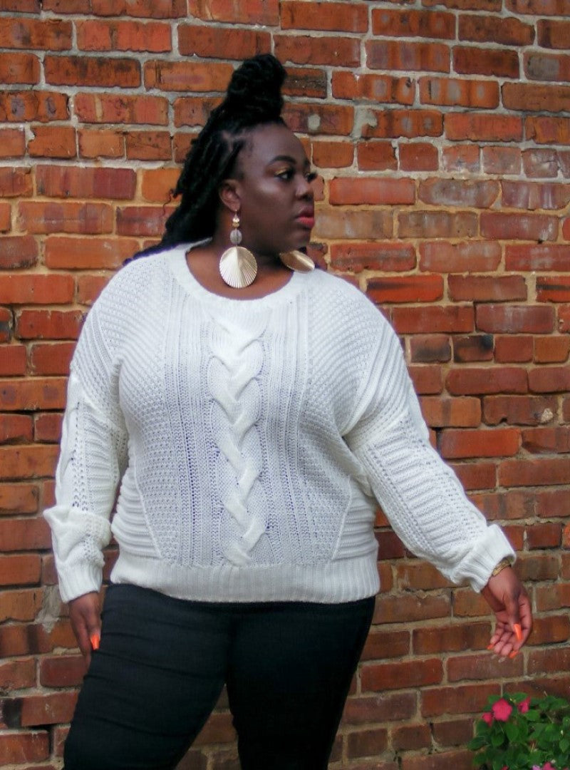  Carmen is an ivory white, medium knit sweater with a fun braided pattern along the center front. This sweater is perfect for the fall and can be paired in endless ways. Shop the Carmen Sweater today.